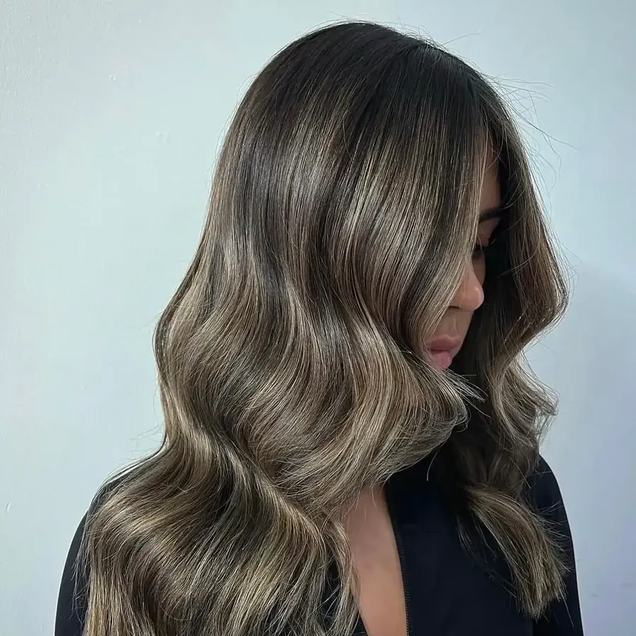 Brunette balayage with hand-painted highlights and soft waves