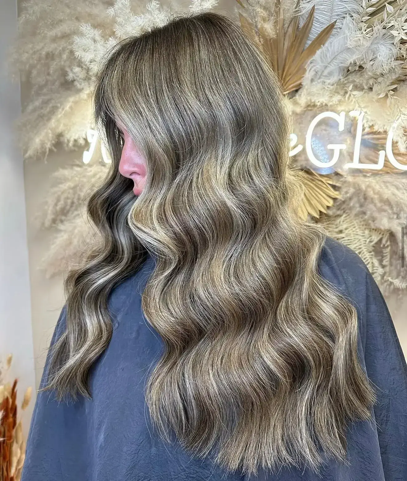 Brunette nano-bond extensions styled into long glossy waves